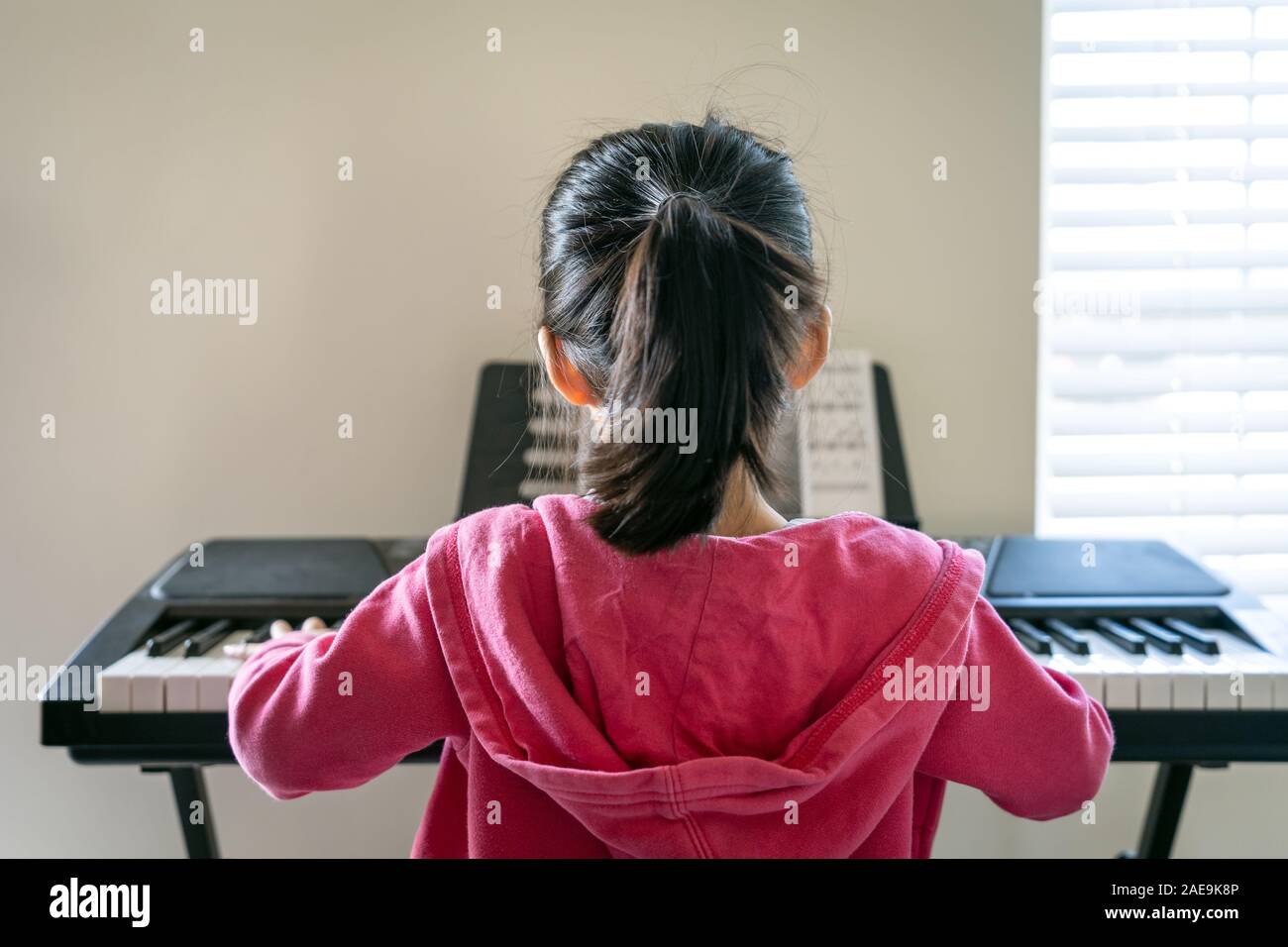 Poco ragazza asiatica la riproduzione di tastiera Foto Stock