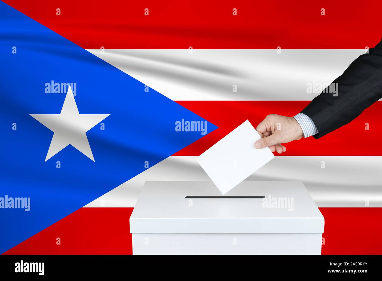 Elezione a Porto Rico. La mano dell'uomo che mette il suo voto nella cassa di voto. Bandiera di Puerto Rico ondulato sullo sfondo. Foto Stock