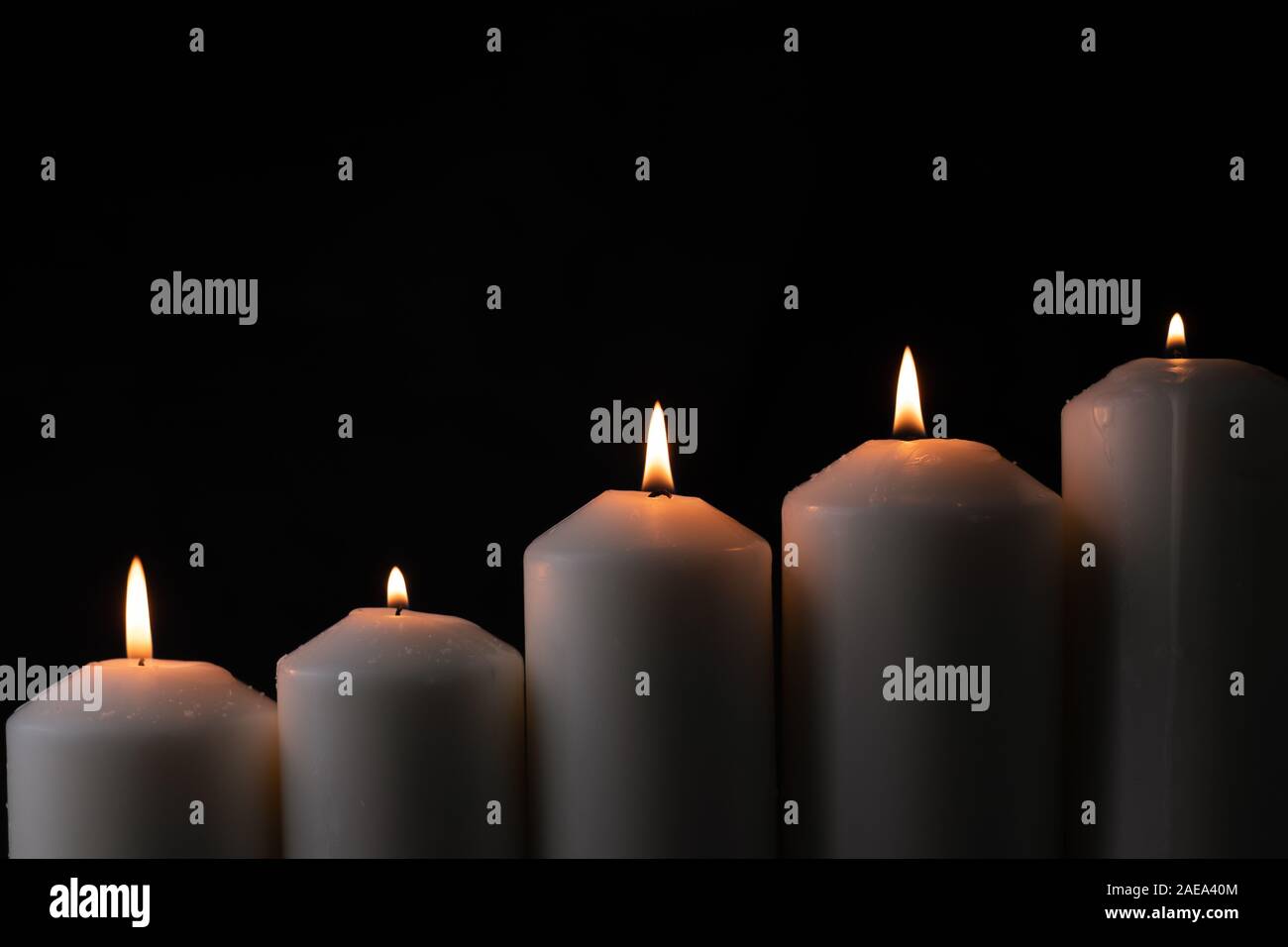 5 luce di candela di fiamma che brucia ardentemente su sfondo nero Foto Stock