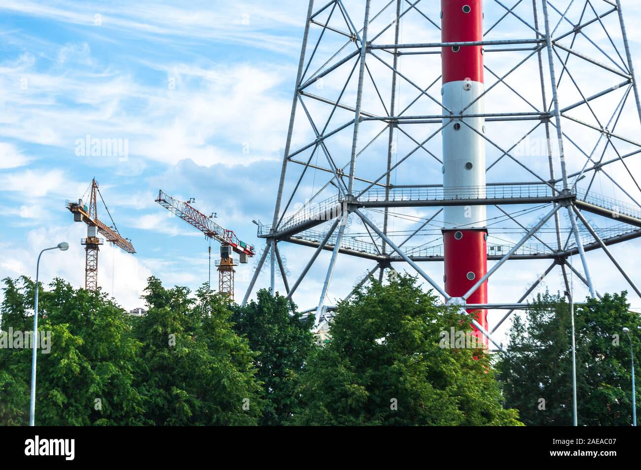 Chiudere la vista di San Pietroburgo TV Tower circondata da alberi con gru edili nelle vicinanze Foto Stock