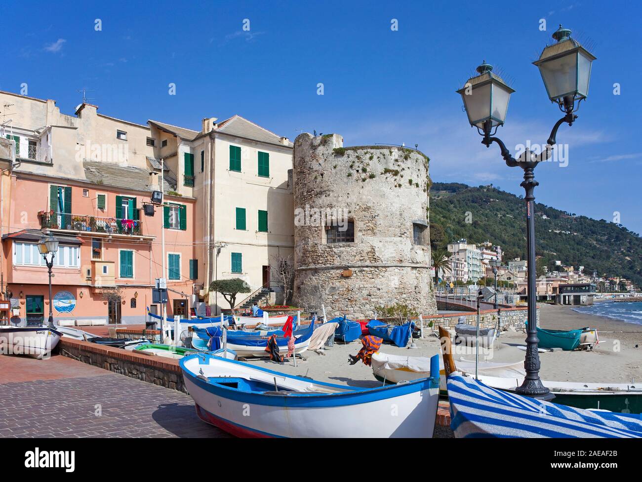 Guardare la medievale torre bastione baluardo e barche di pescatori sulla spiaggia di Laigueglia, costa ligure, Liguria, Italia Foto Stock