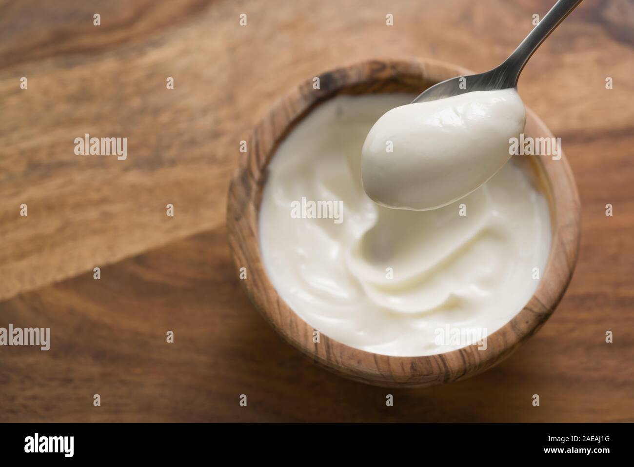 Pov colpo di cucchiaio colmo di yogurt, fondale focus Foto Stock