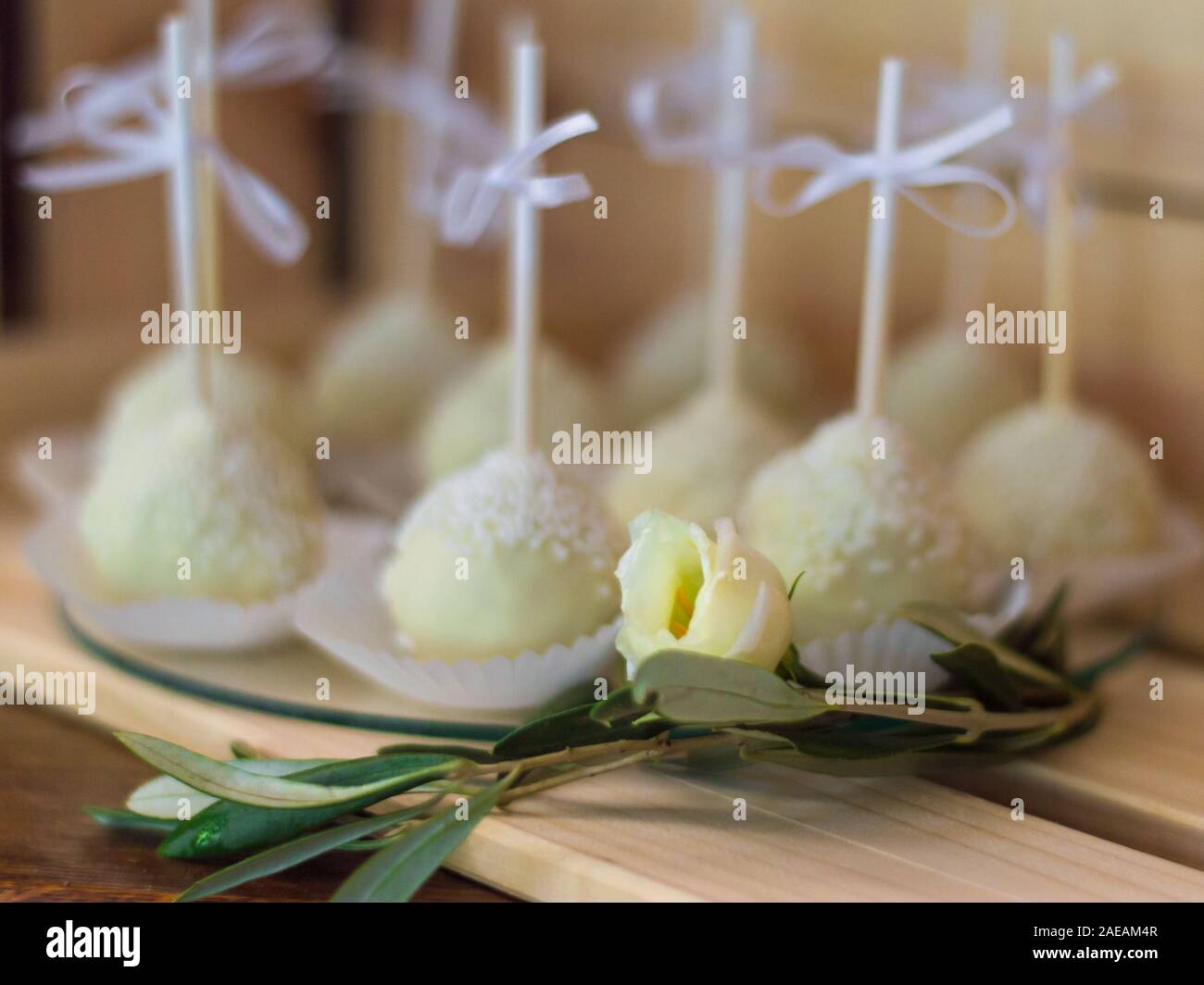 Molti white panini dolci e una rosa bianca di fronte a loro Foto Stock