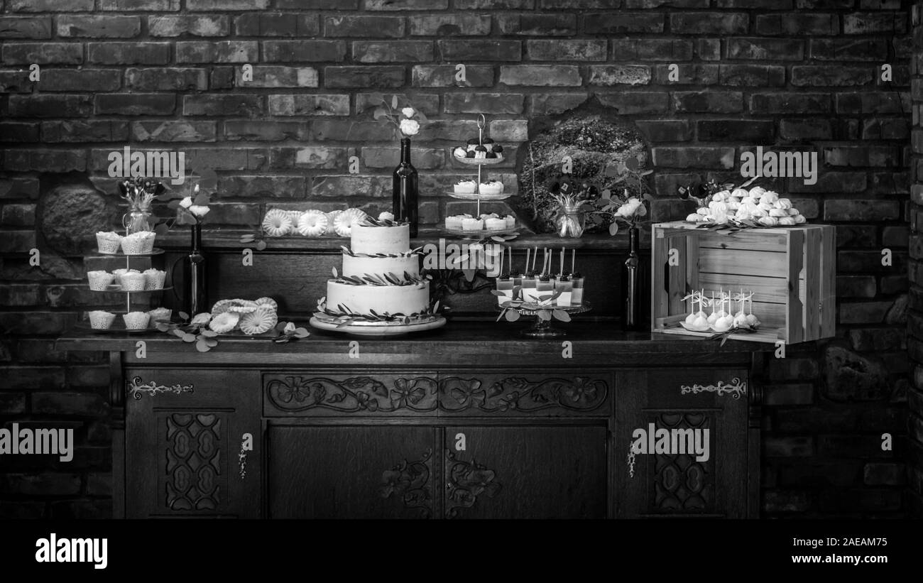 Bella dolce decorato tavolo con tortine, focaccine dolci di gel, torta di nozze, marshmallows e altri goodies Foto Stock