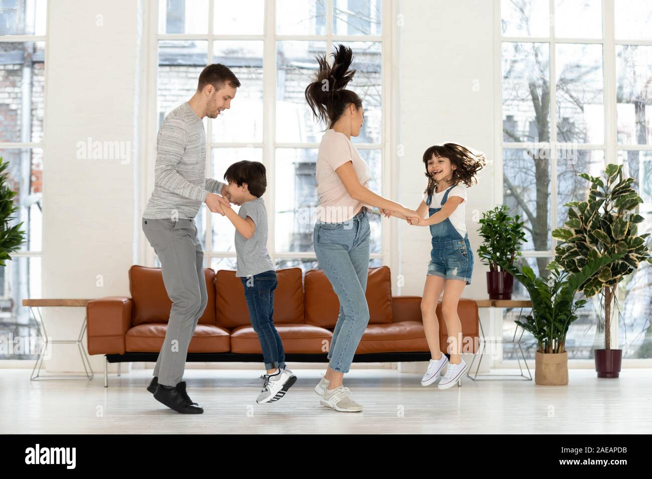 Felice madre e padre di due figli di saltare in ballo. Foto Stock