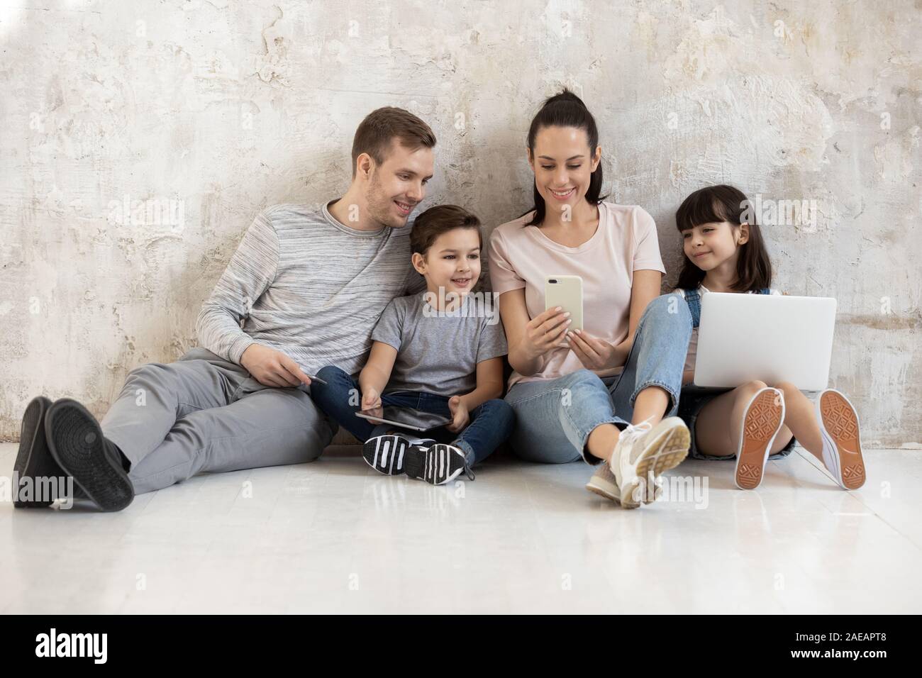 Felice famiglia con due bambini carino guardare video sullo smartphone. Foto Stock