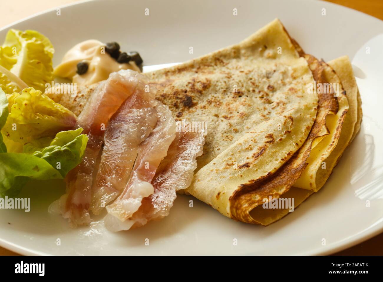 Gravlax con pancake servita foglie di insalata Foto Stock