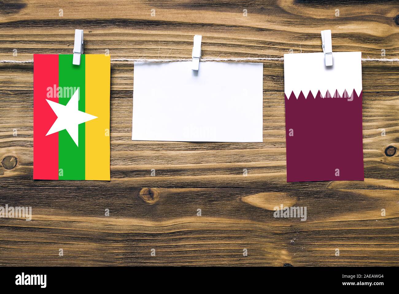 Appendere bandiere di Myanmar e Qatar attaccata alla corda con vestiti perni con copia spazio bianco sulla nota carta su sfondo di legno.Le relazioni diplomatiche essere Foto Stock