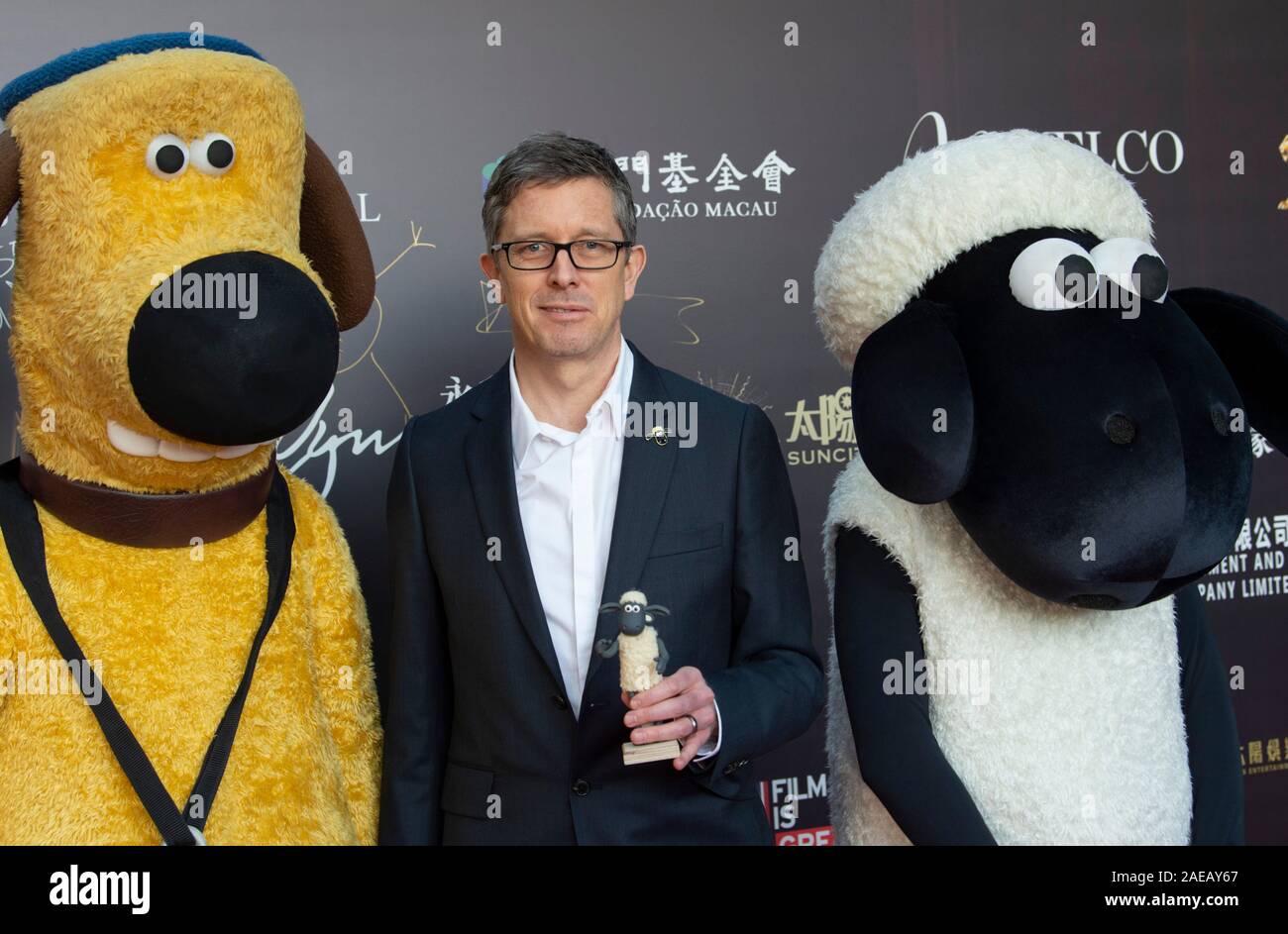Macao, Cina. 08 Dic, 2019. Il quarto Festival Internazionale del Film & Awards Macao 2019 (IFFAM) Giorno 4. Tappeto rosso arrivi- Paolo Kewley (m), direttore di "Shaun la pecora Movie:Farmageddon" con la Bitzer Sheepdog (L) e Shaun la pecora (R). Credito: HKPhotoNews/Alamy Live News Foto Stock