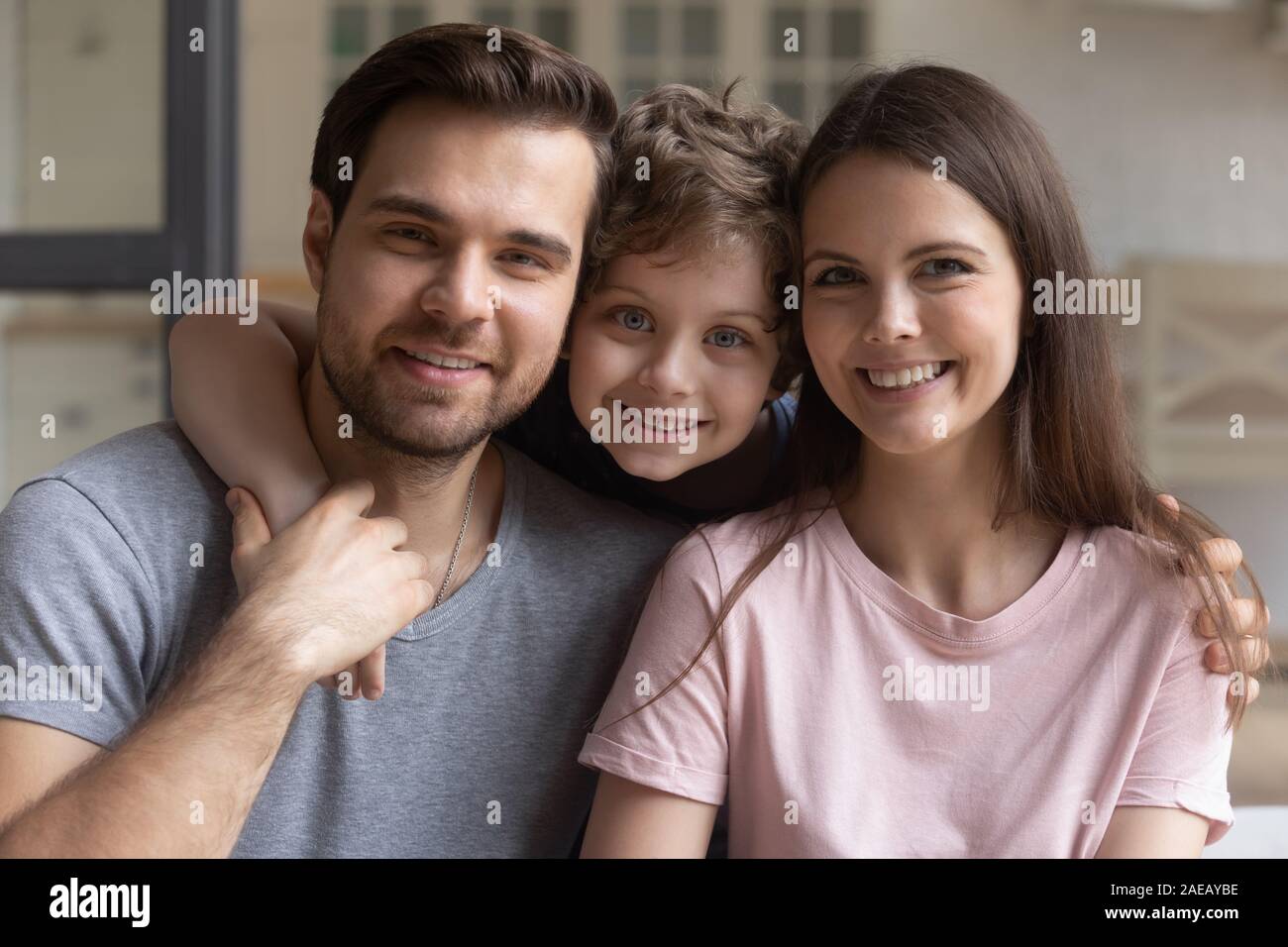 La famiglia felice papà e mamma piccolo figlio di posa per la fotocamera Foto Stock