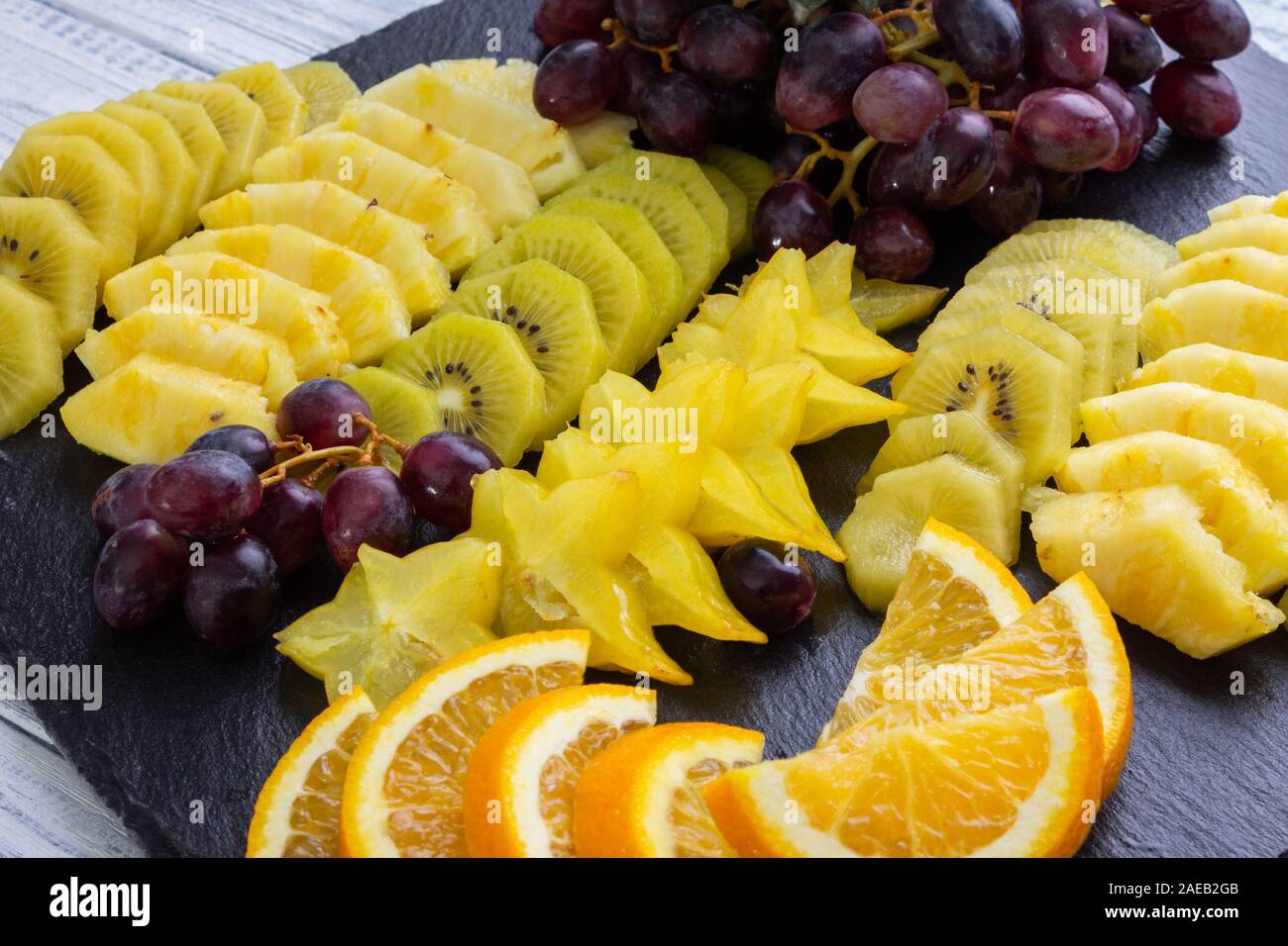 Frutta a fette su una piastra - ananas - Arancio - Uva - Kiwi- Starfruit Foto Stock
