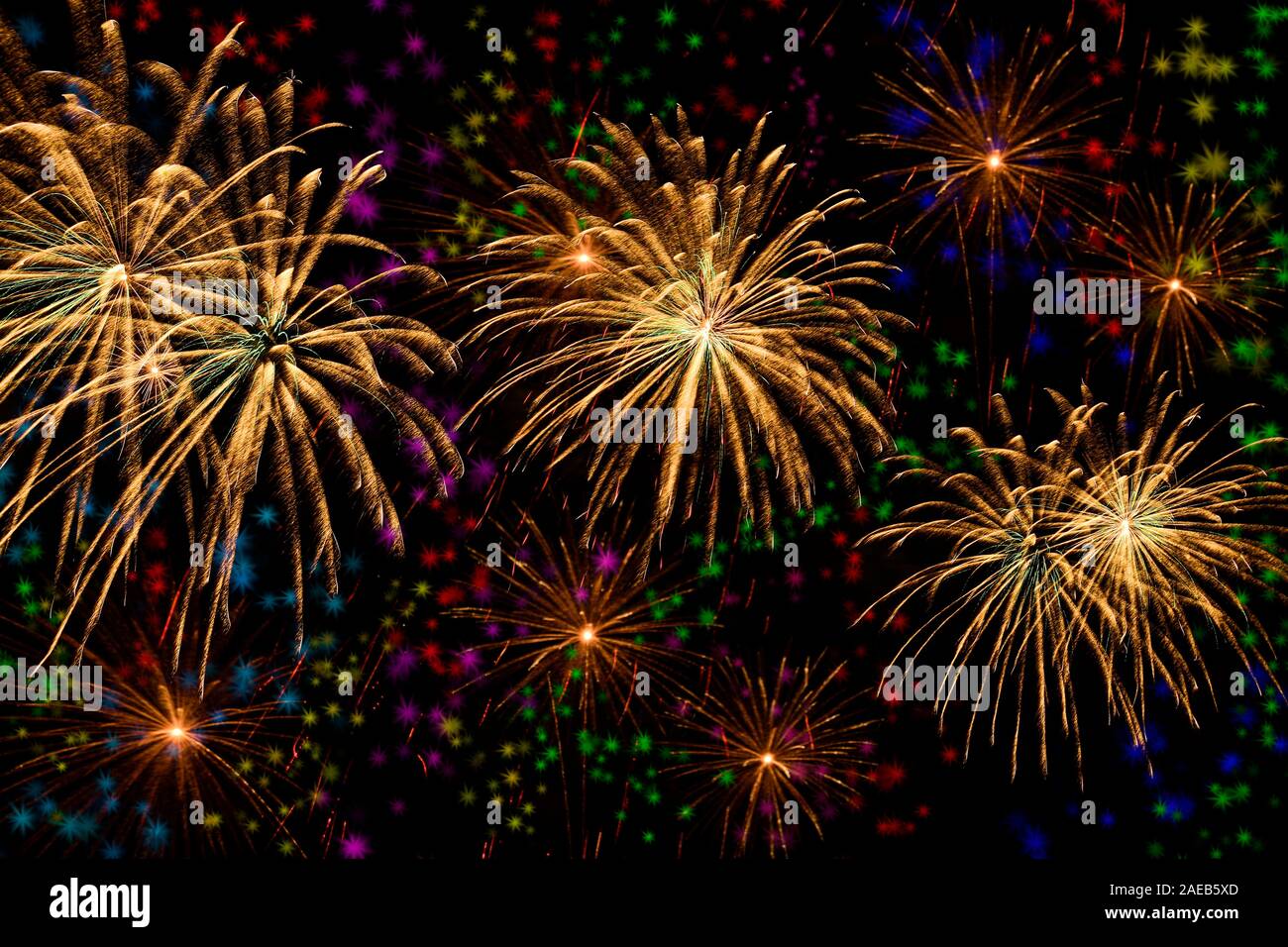 Oro fuochi d'artificio celebrazione sulla stella colorata lo sfondo e la mezzanotte sullo sfondo del cielo. Foto Stock