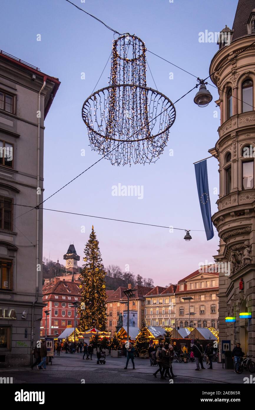 Mercatino di Natale Christkindlmarkt sulla piazza principale con la collina Schlossberg e landmark Uhrturm in Graz, Stiria, Austria Foto Stock