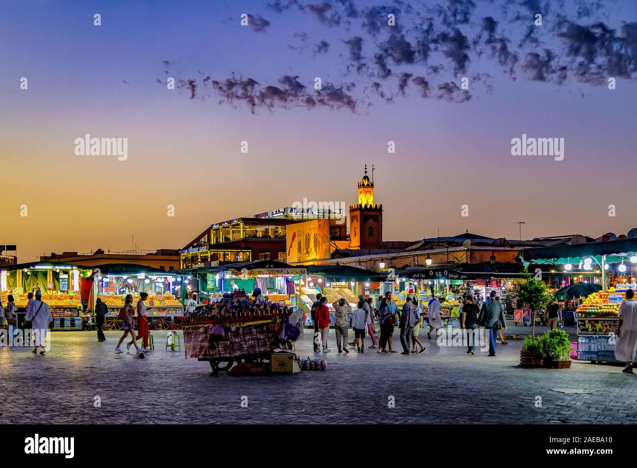 Vivace piazza principale al tramonto a Patrimonio Mondiale UNESCO Piazza Jamaa El Fna piazza del mercato nella Medina di Marrakech,Marocco.Fornitori, artisti e turisti. Foto Stock