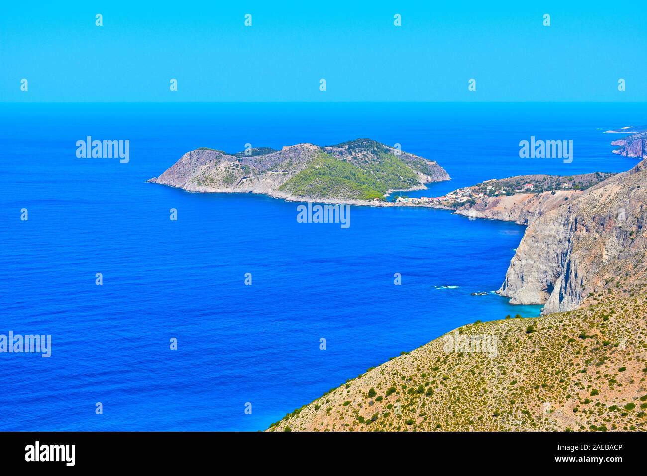 Un elevato vista costiera del grazioso villaggio di pescatori di Assos, che si accoccola nel riparo dell'isola completa con antico forte sulla parte superiore. Foto Stock