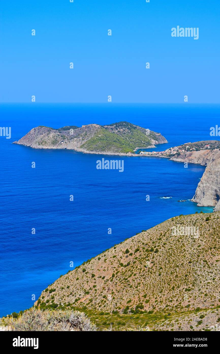 Un elevato vista costiera del grazioso villaggio di pescatori di Assos, che si accoccola nel riparo dell'isola completa con antico forte sulla parte superiore. Foto Stock
