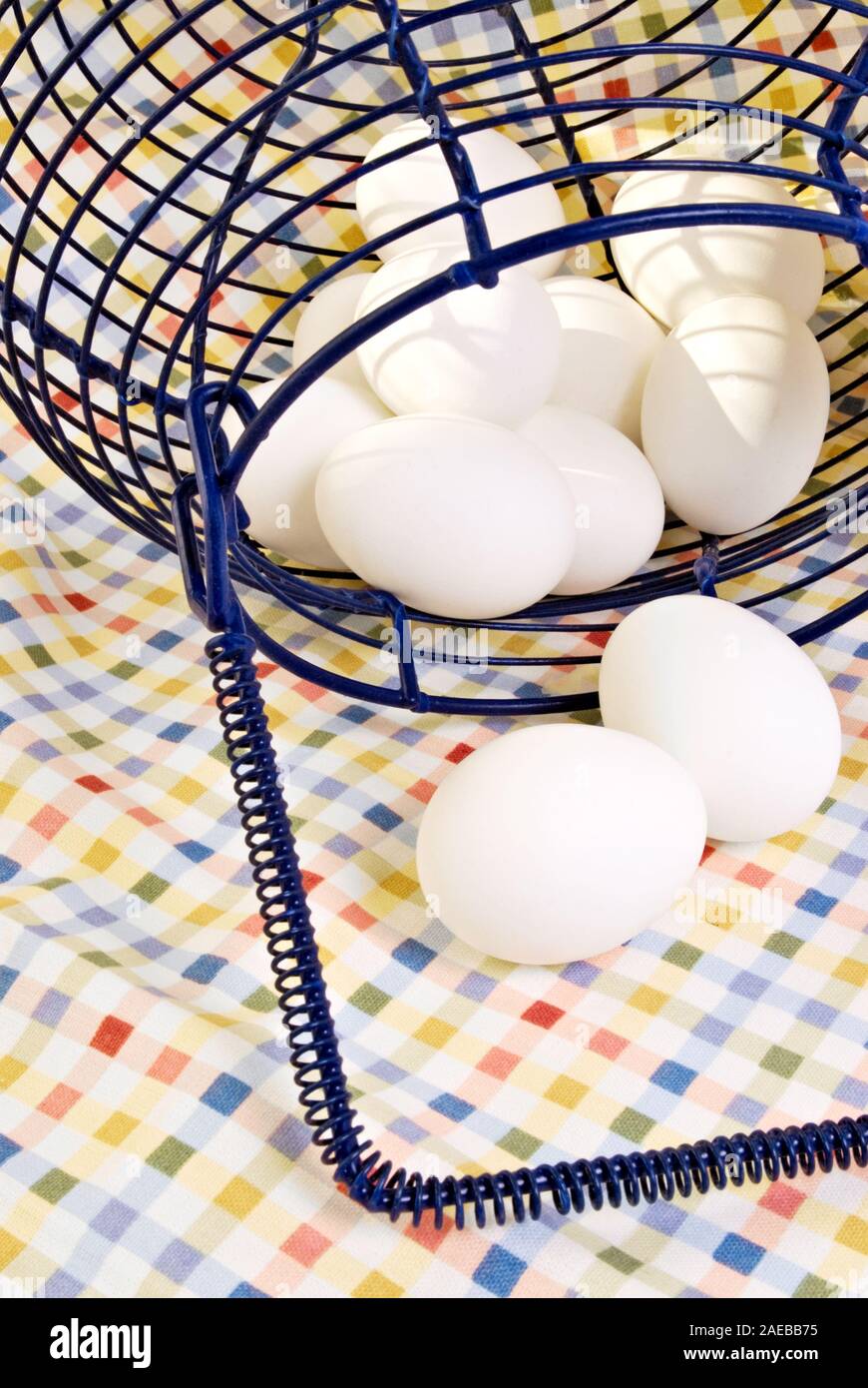 Bianco uova sode in un blu navy fili decorativi incorniciati cestello. Girato in interni a luce naturale del giorno. Foto Stock