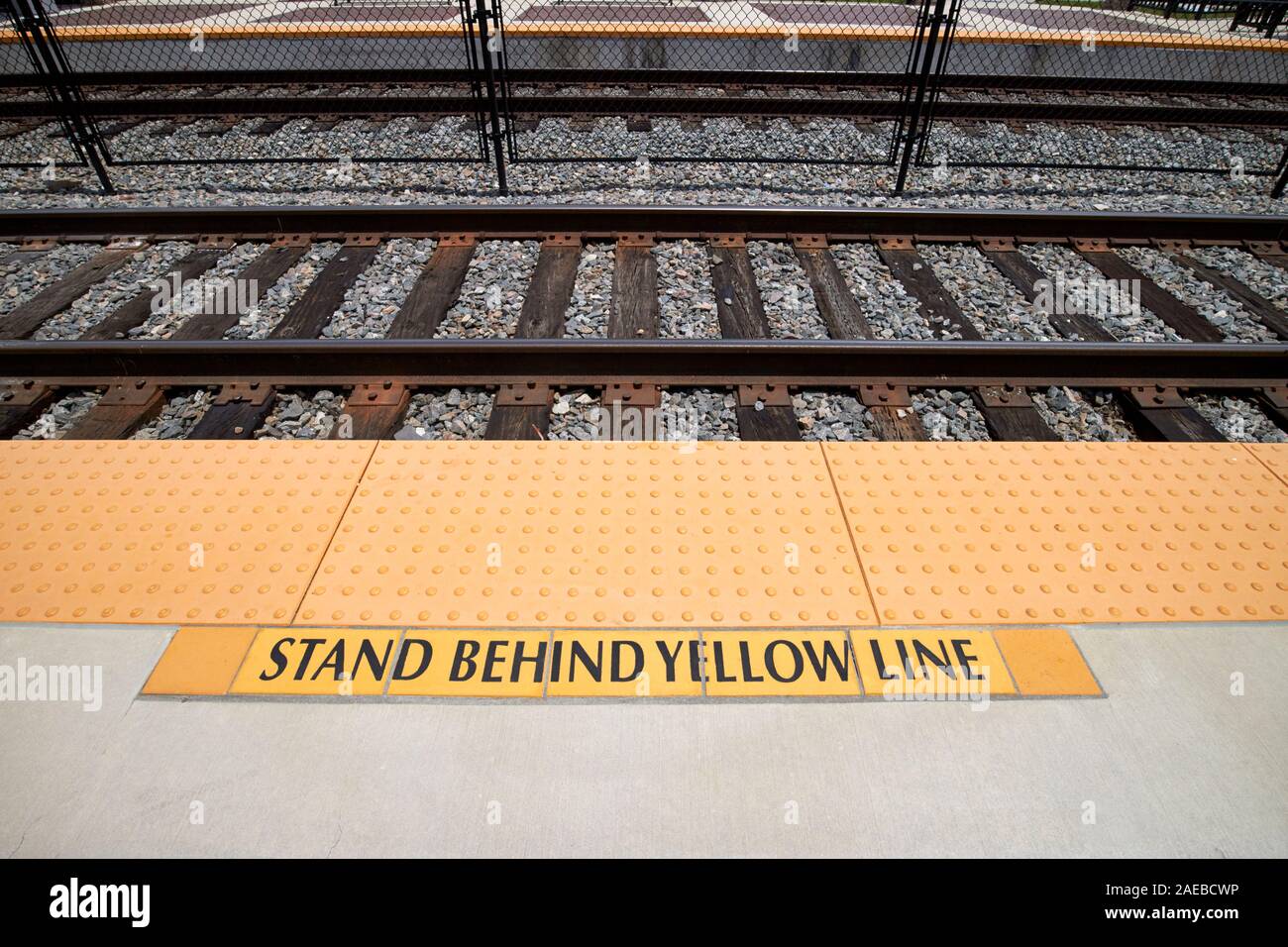 Stare dietro la linea gialla segnale di avvertimento con bordo a trama della piattaforma piastrelle kissimmee stazione ferroviaria kissimmee florida usa Foto Stock