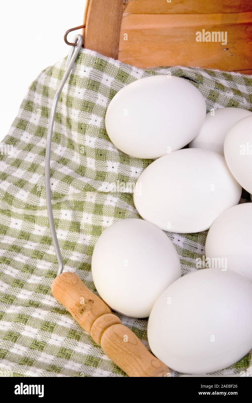 Bianco uova sode in un vecchio legno cesto decorativo. Girato in interni a luce naturale del giorno. Foto Stock