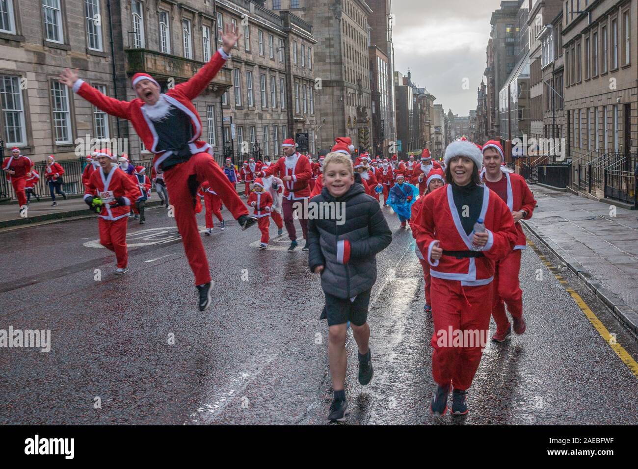 Glasgow, Regno Unito. 8 dicembre 2019. L annuale 5K Santa Dash da George Square con circa 8000 persone vestite come Santa la corsa sotto la pioggia e la raccolta di fondi per beneficenza. Credito: Richard Gass/Alamy Live News Foto Stock