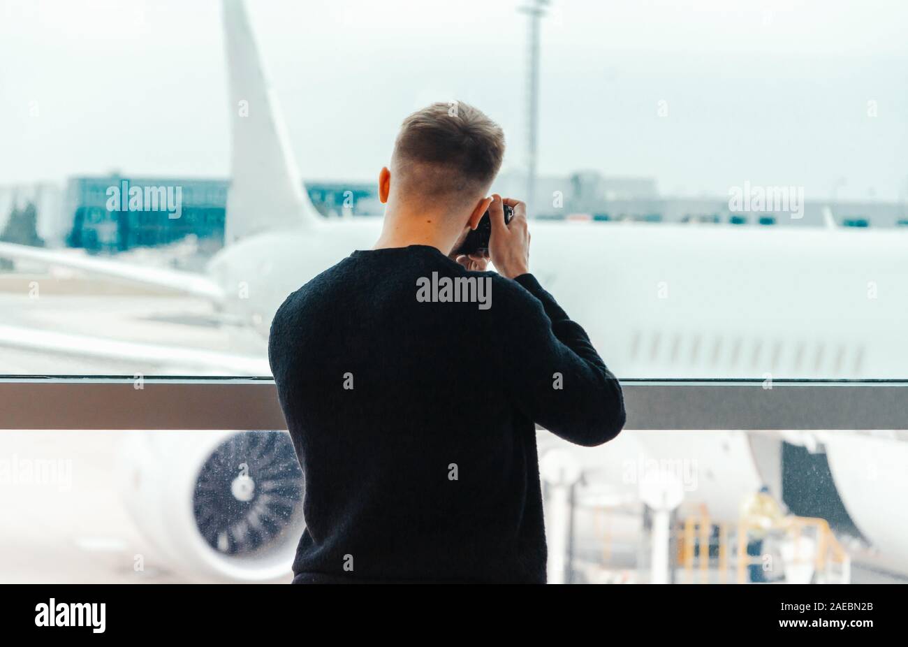 Giovani blogger fotografo facendo una foto del jet di pista prima di decollare. Concetto moderno di viaggiare e di blog. Foto Stock