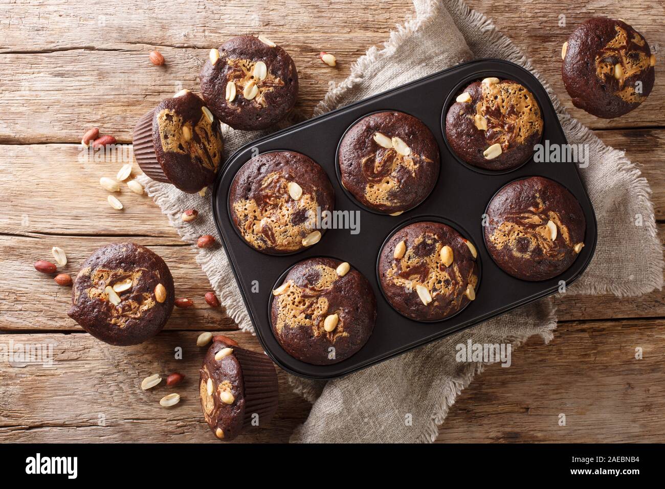 Cioccolato fondente muffin vegetariano con burro di arachidi e le noci in una teglia sul tavolo. Parte superiore orizzontale vista da sopra Foto Stock