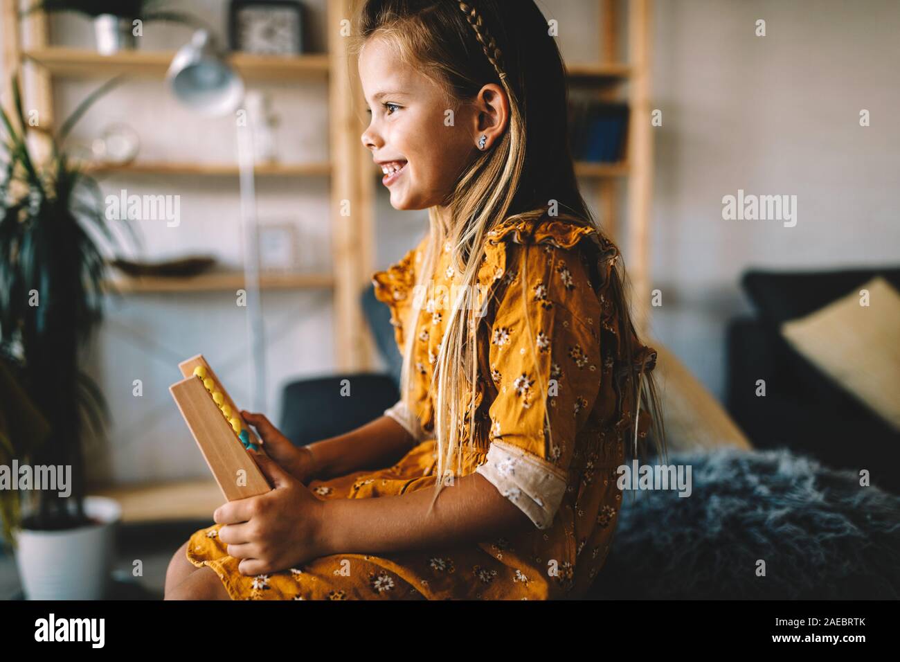 Poco intelligente ragazza che gioca con abacus a casa Foto Stock