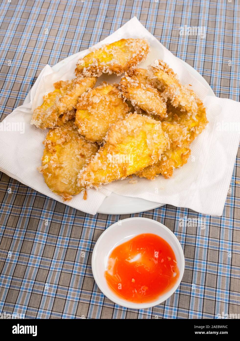 Frittelle di patate dolci fritte ricoperte di cocco servite a tavola, in Vietnam, nel sud-est asiatico Foto Stock