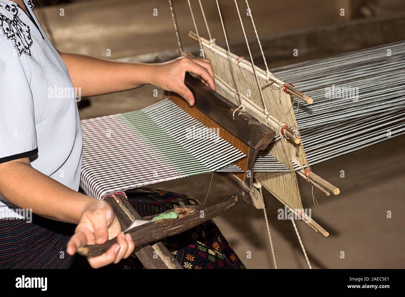 Tessitura con una navetta su un tradizionale stile Lao-Thai telaio, divieto di Phnom, Laos Foto Stock