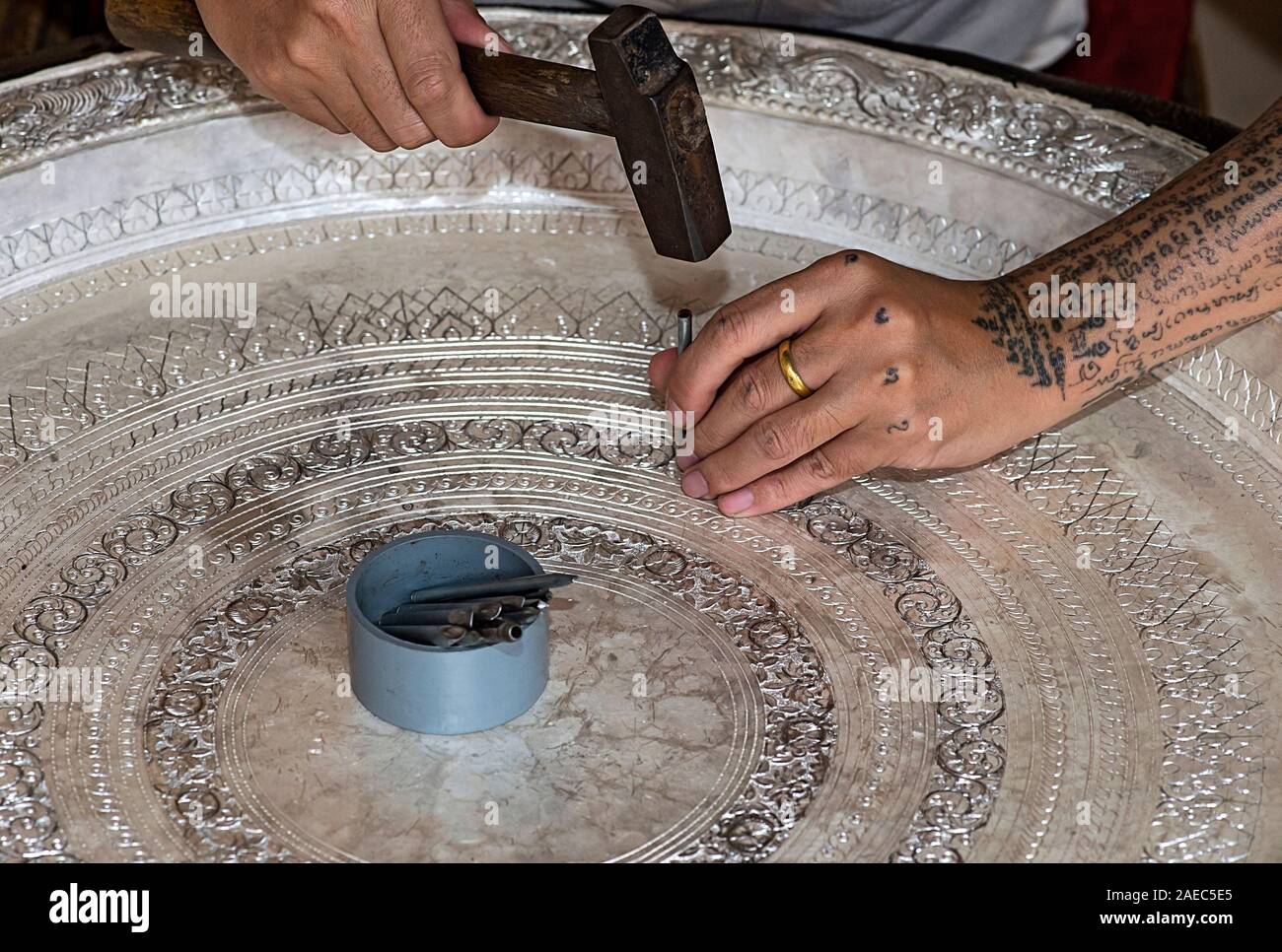 Incisione argentiere una ciotola in argento con martello e chisle, divieto di Phnom, Laos Foto Stock