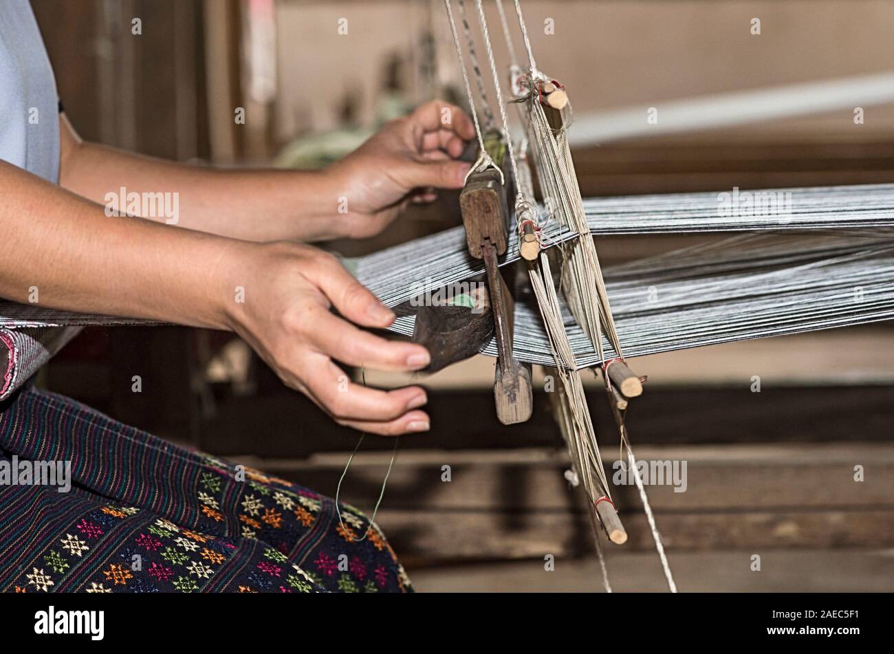 Tessitura con una navetta su un tradizionale stile Lao-Thai telaio, divieto di Phnom, Laos Foto Stock