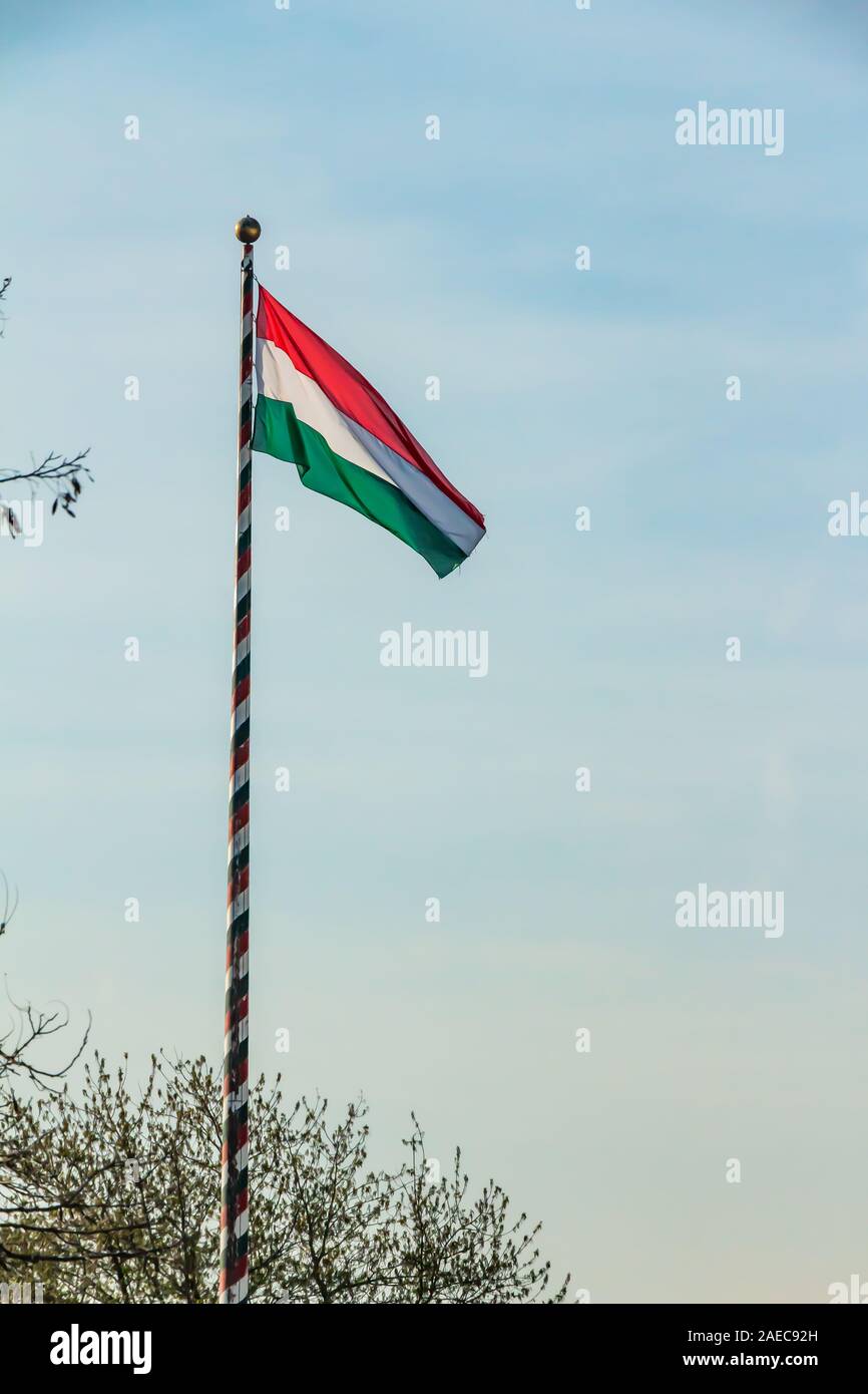 Ungheria, nazionale ungherese di bandiera sventola sul cielo blu sullo sfondo Foto Stock