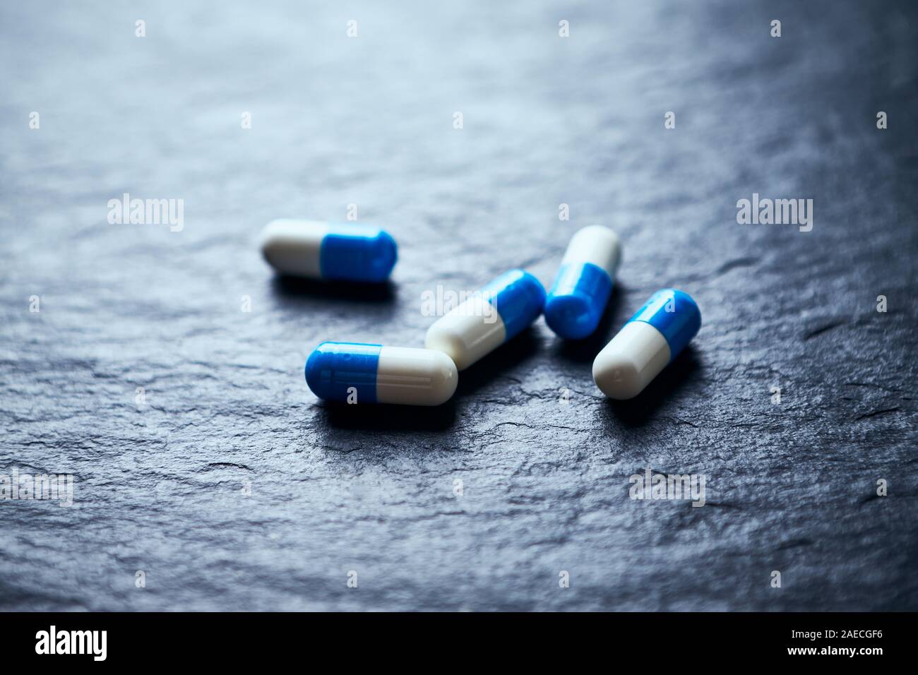 Sport supplementi (creatina capsule) di pietra scura sullo sfondo. Close up. Foto Stock