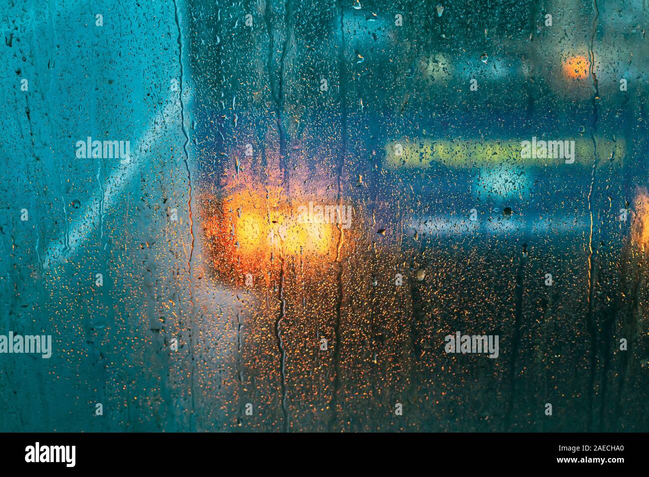 Gocce di pioggia sul vetro su sfondo di vetro. Abstract Street sfondo colorato. Foto Stock