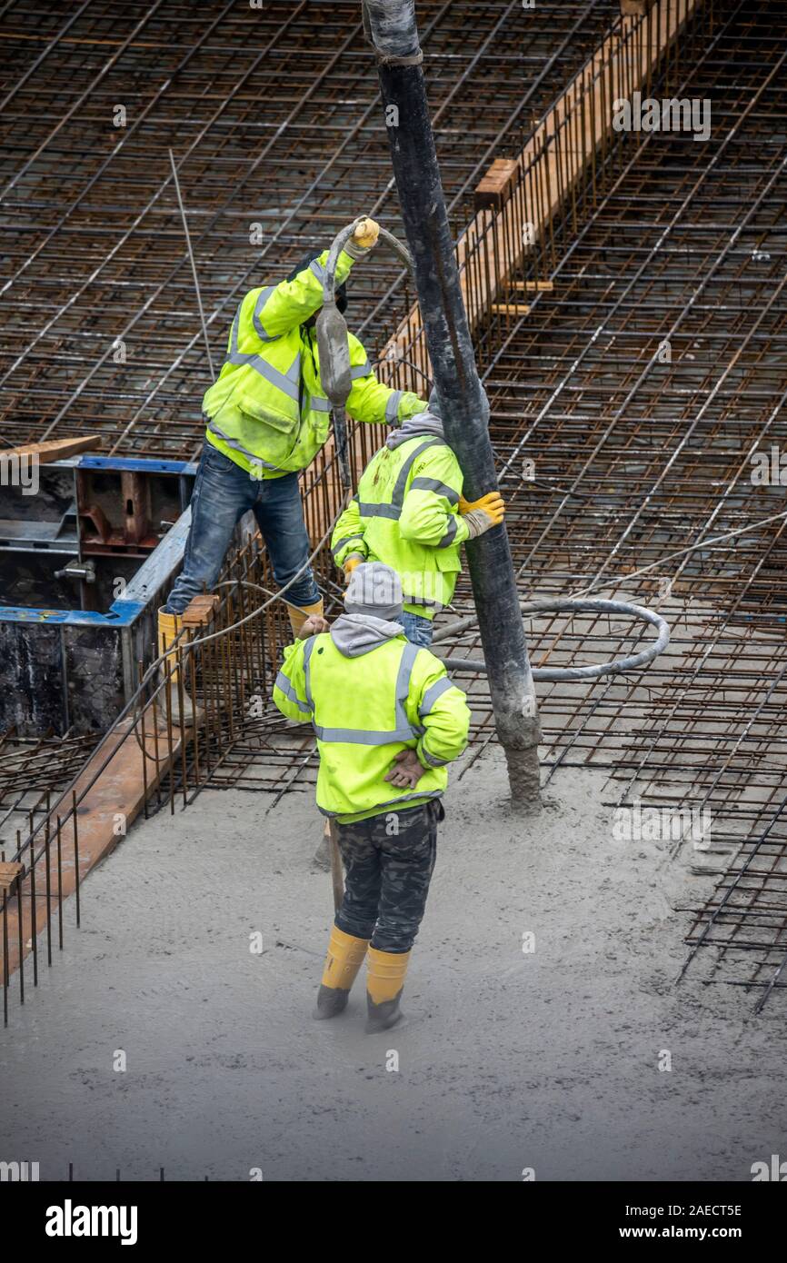 Sito in costruzione, cementificazione, la fondazione di un edificio è rivestite di cemento, calcestruzzo è pompato sul ferro acciaio calcestruzzo stuoie, Foto Stock