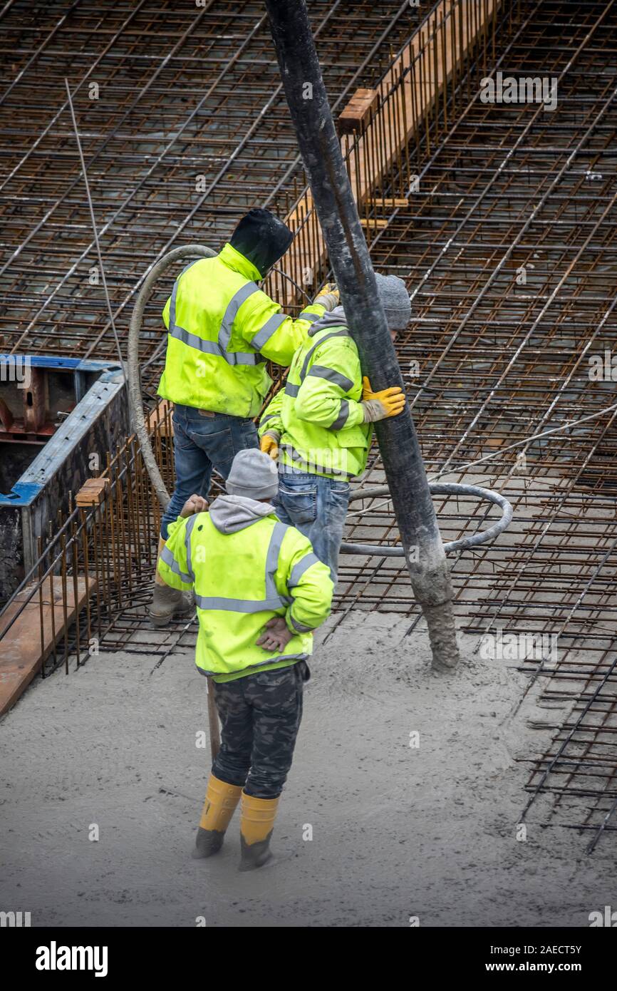 Sito in costruzione, cementificazione, la fondazione di un edificio è rivestite di cemento, calcestruzzo è pompato sul ferro acciaio calcestruzzo stuoie, Foto Stock