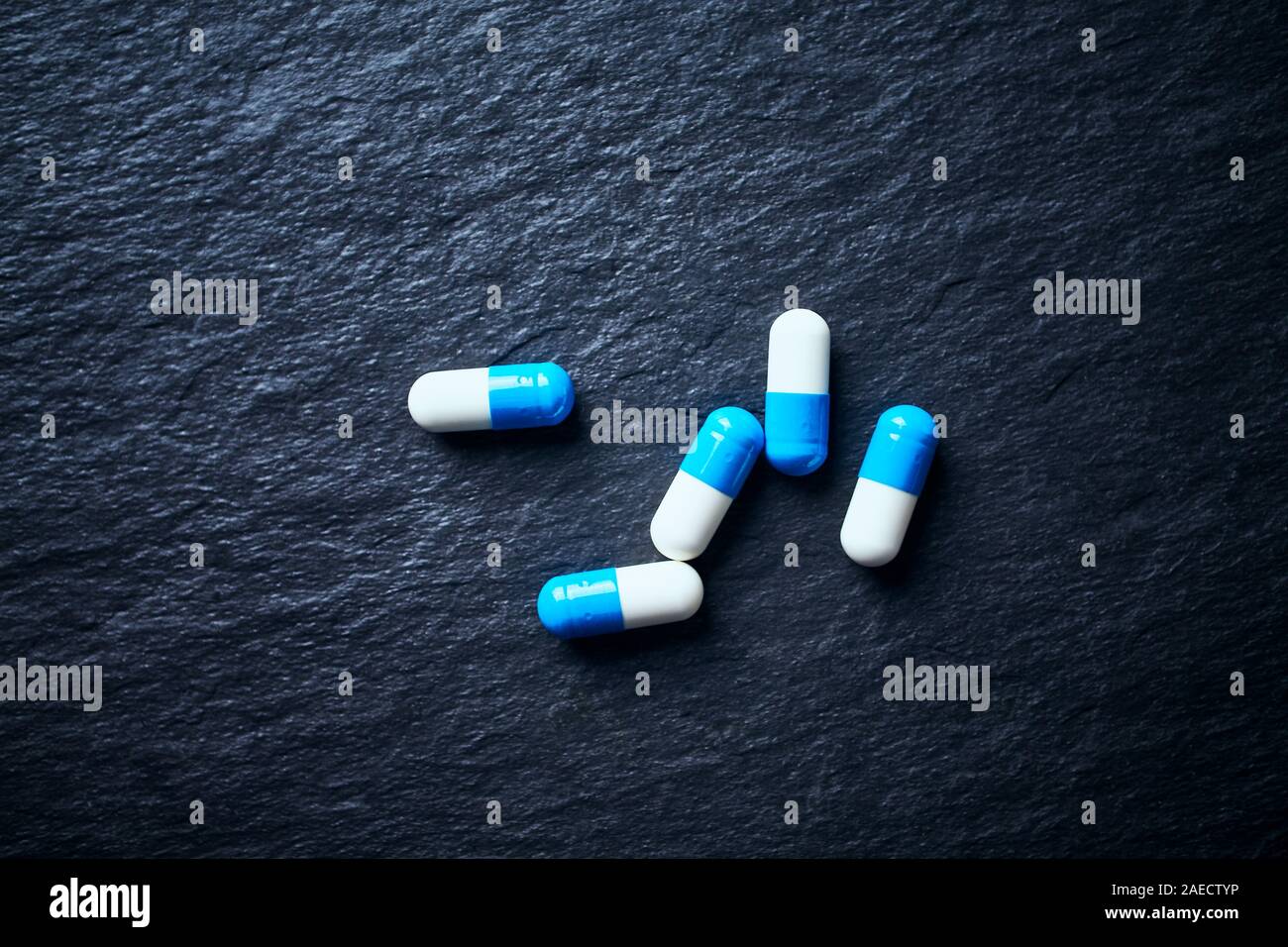 Sport supplementi (creatina capsule) di pietra scura sullo sfondo. Vista dall'alto. Foto Stock