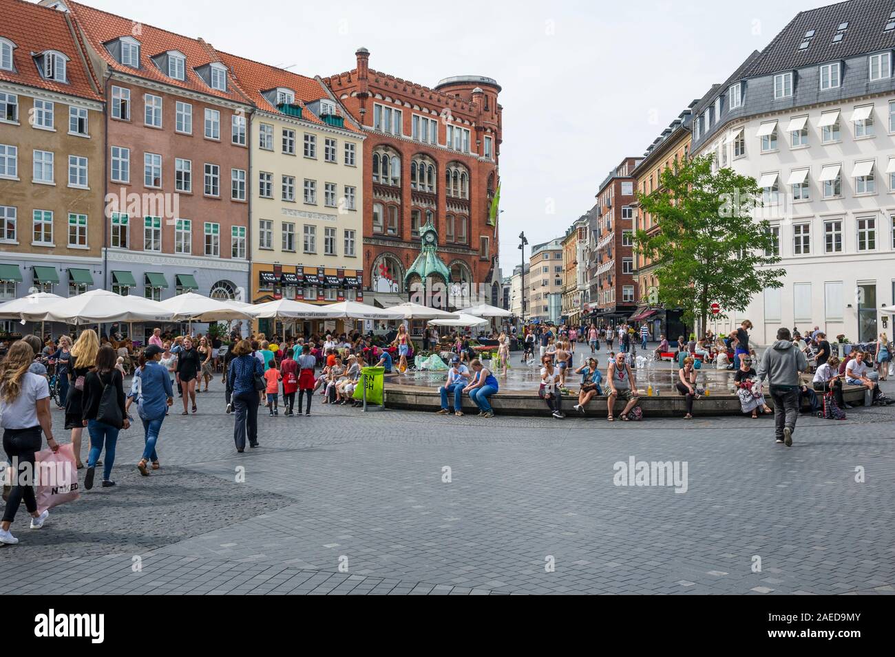 Persone rilassante da una fontana in piazza a Copenhagen, Danimarca Foto Stock