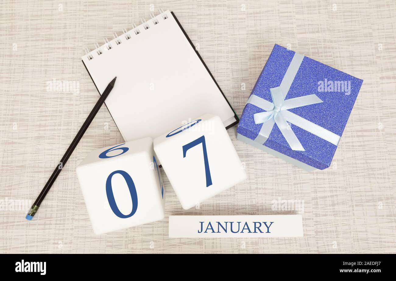 Calendario con blu alla moda il testo e i numeri per il 7 gennaio e un regalo in una scatola. Foto Stock