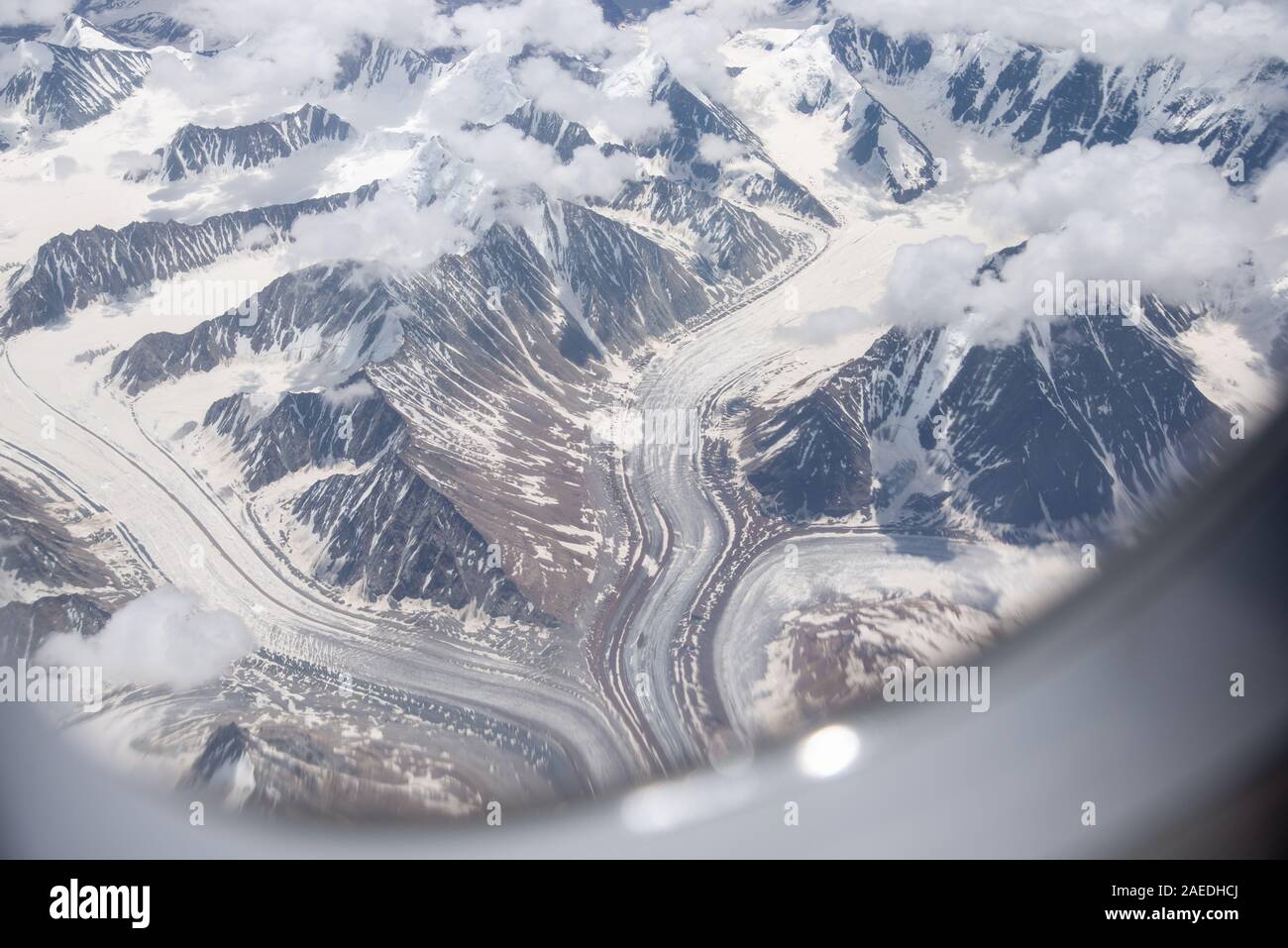Vista attraverso la finestra di aeroplano a montagne innevate e ghiacciai dell Himalaya in Ladakh, India settentrionale Foto Stock
