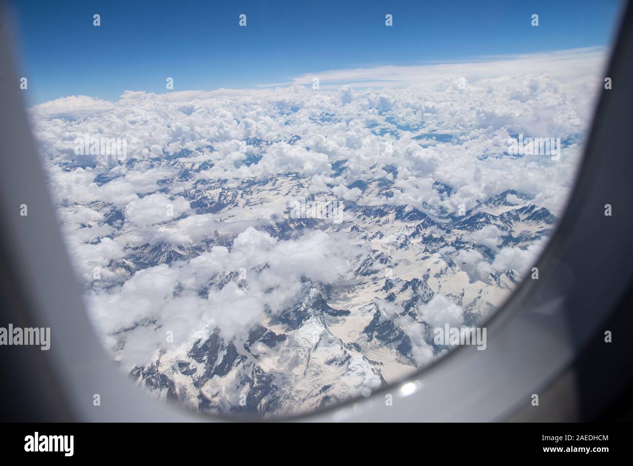 Vista attraverso la finestra di aeroplano a montagne innevate dell'Himalaya in Ladakh, India settentrionale Foto Stock
