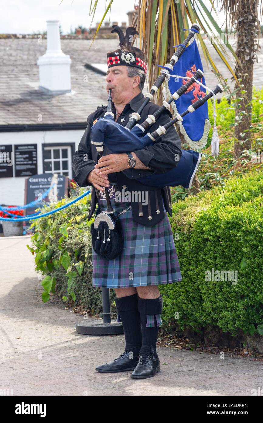 Tradizionale Scozzese, bagpiper Gretna Green famoso Fabbri Shop, Gretna Green, Gretna, Dumfries and Galloway, Scotland, Regno Unito Foto Stock