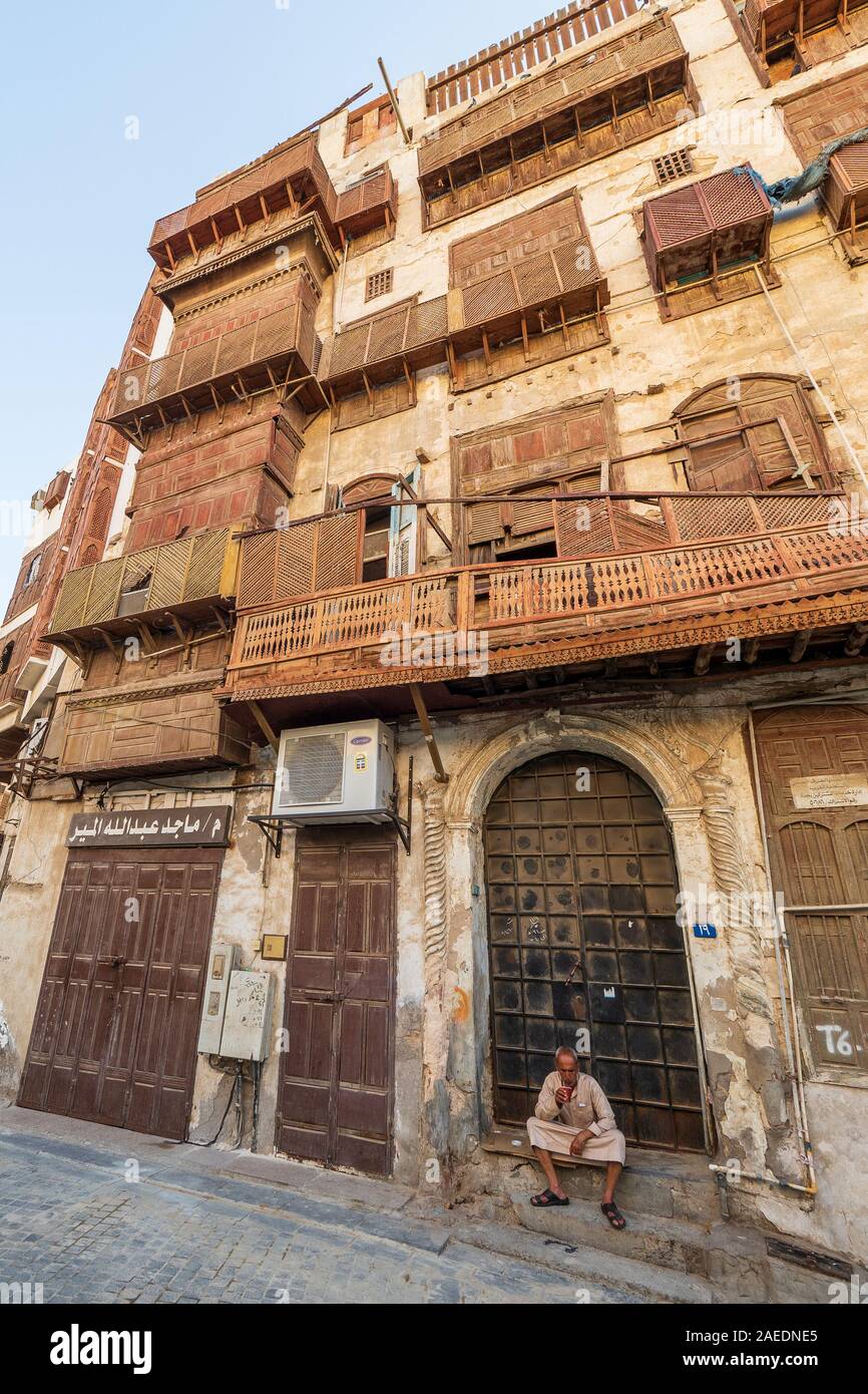 Arabo senior seduti sui gradini davanti alla porta di un corallo town house nel quartiere storico Al Balad in Jeddah, KSA, Arabia Saudita Foto Stock