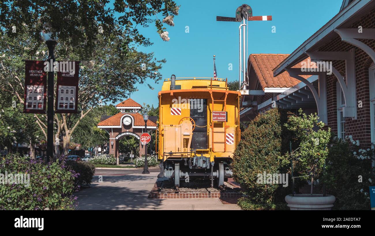 Giardino d'inverno, Florida: 29 maggio 2019 - giallo storico vagone ferroviario di fronte alla torre dell Orologio e vicino al museo del patrimonio in downtown area. Foto Stock