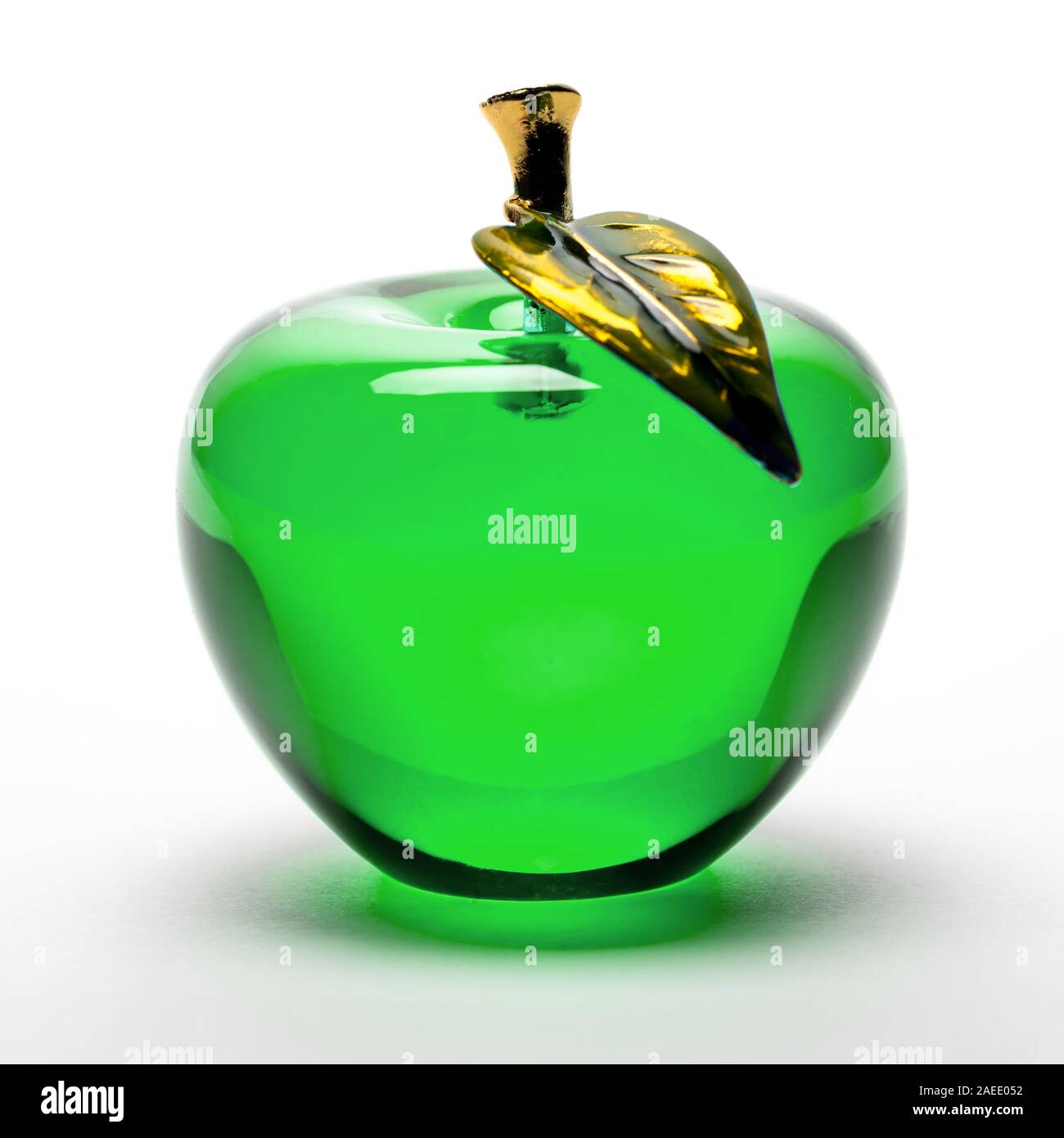 Mela Verde di Figurine di vetro su sfondo bianco con stelo metallico e foglia. Foto Stock