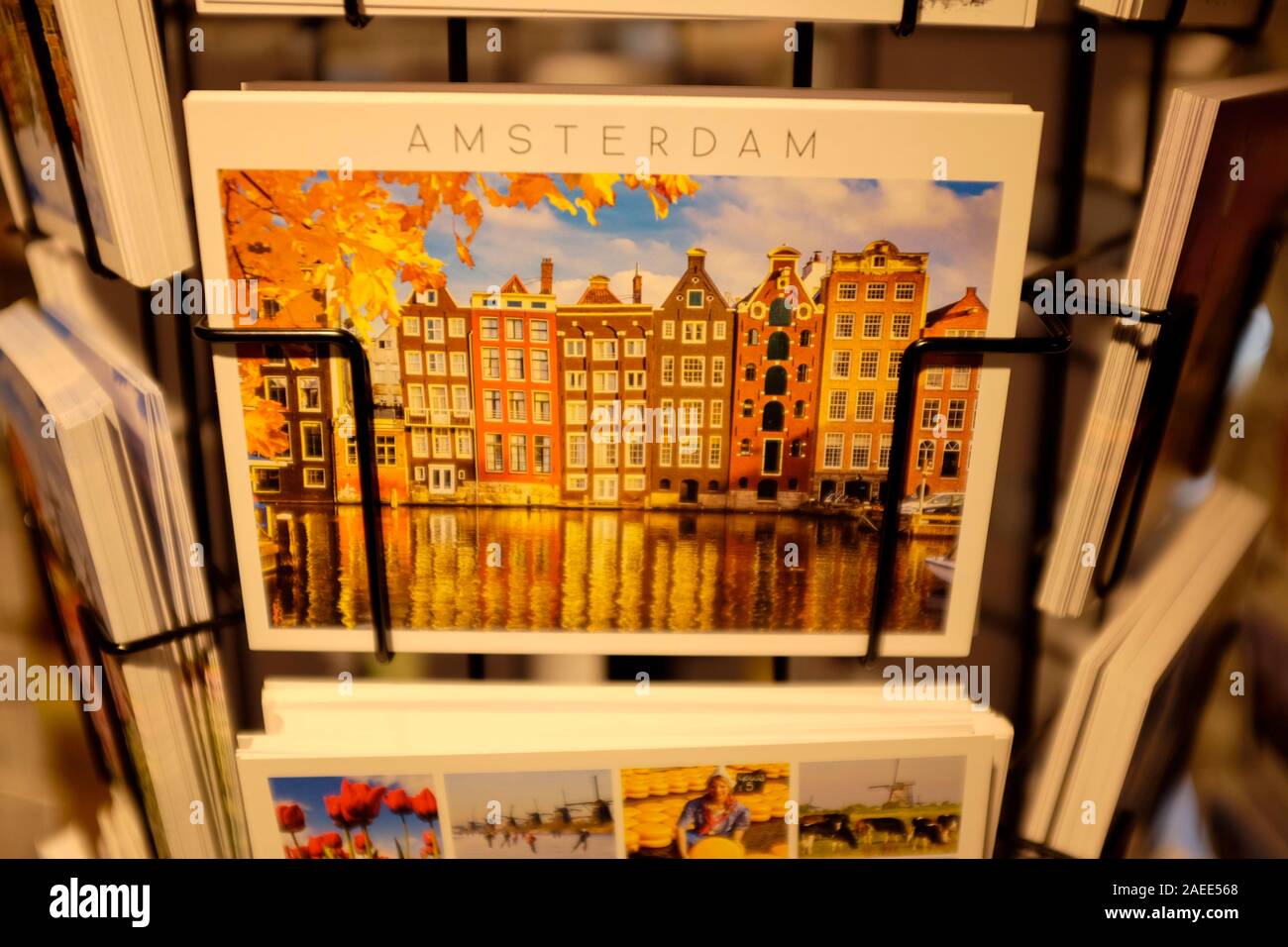 Cartoline colorate di Amsterdam in vendita in rack presso un negozio di souvenir, i Paesi Bassi. Foto Stock