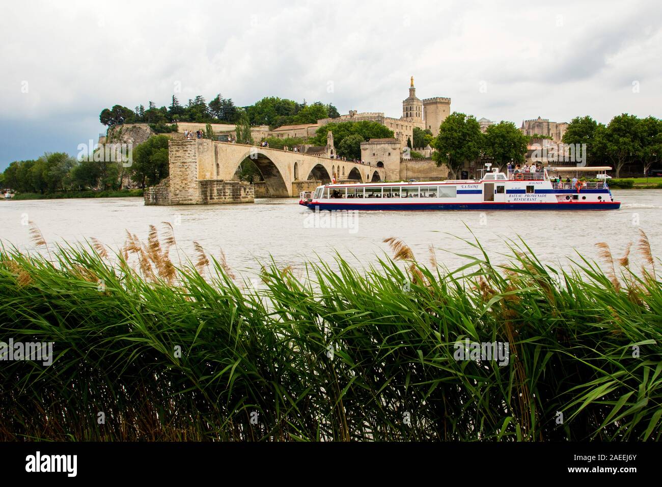 Una barca passa il Pont d'Avignon spanning in parte attraverso il Rodano a Avignon Francia Foto Stock