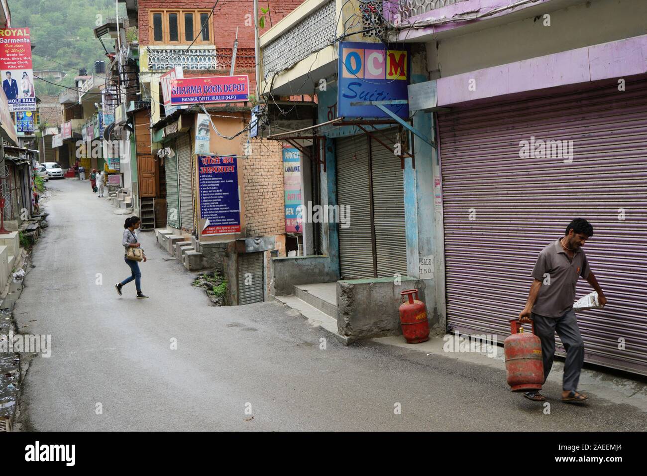 Uomo che porta bombola del GPL in via stretta, Banjar town, Tirthan Valley, Kullu, Himachal Pradesh, India, Asia Foto Stock