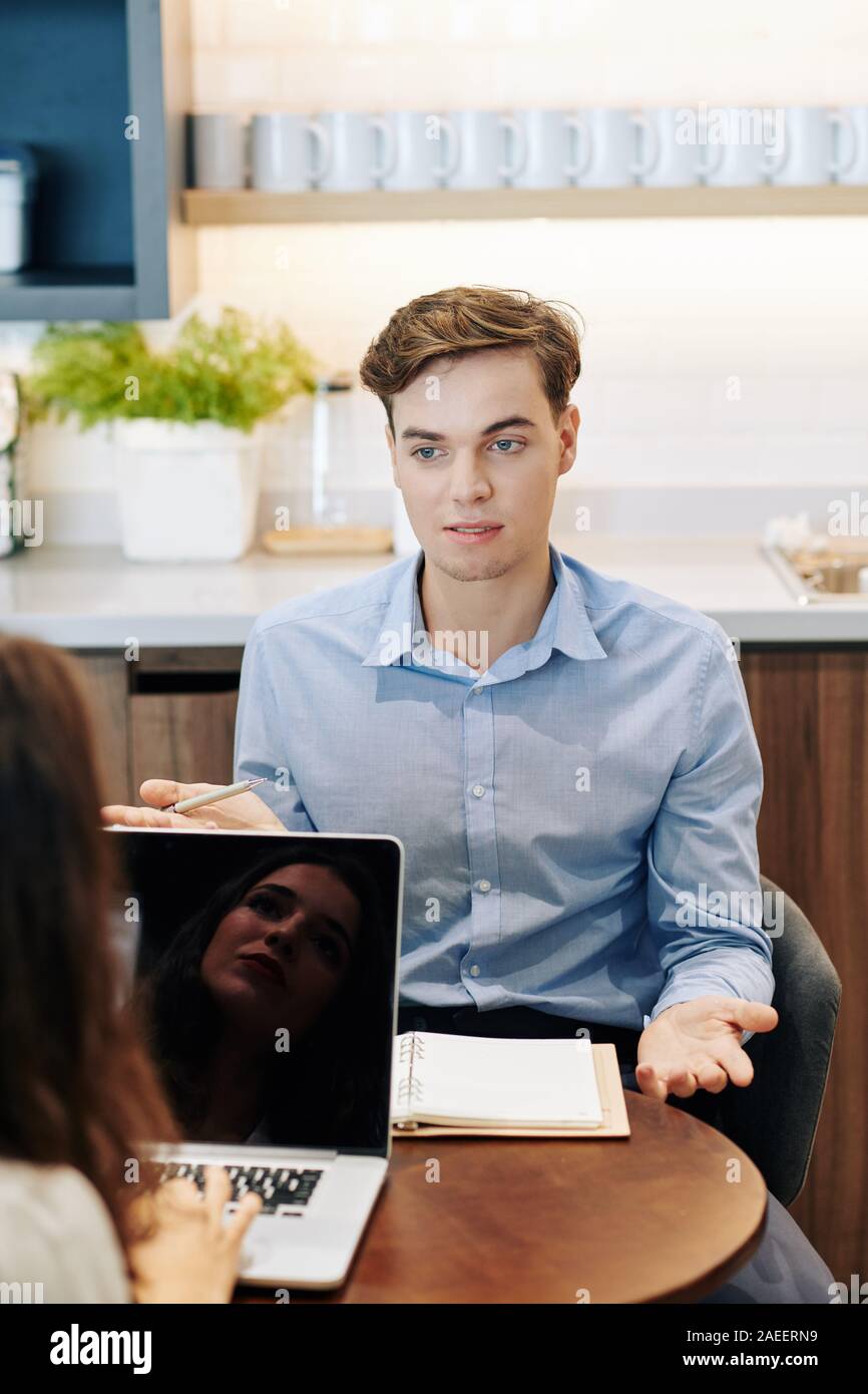 Bel giovane imprenditore incontro con un collega in ufficio cucina e progetto discuccing Foto Stock