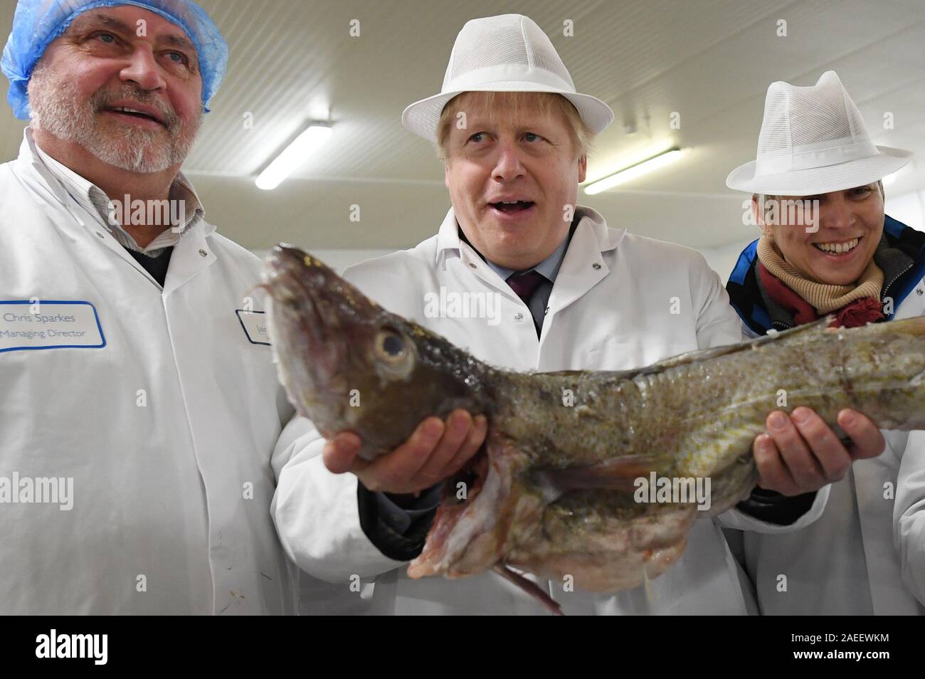 Il primo ministro Boris Johnson detiene un pesce durante una visita a Grimsby Mercato del Pesce, durante la campagna elettorale del trail. Foto Stock